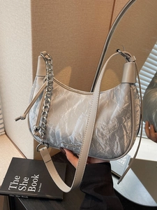 Silver hobo bag with pleated metallic texture, featuring chain and leather straps