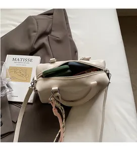 Top view of cream white boston bag showing spacious interior with phone and wallet