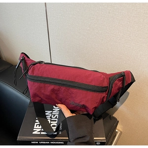 Gros plan sur un sac banane rouge vin en nylon avec des détails de fermeture éclair