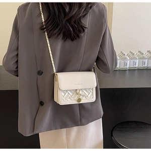 Vue arrière d'un mannequin portant un sac à bandoulière crème avec chaîne dorée