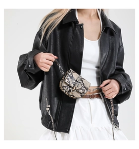 Close-up of stylish mini saddle bag with snakeskin pattern and metallic buckle detail