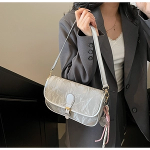 Silver shoulder bag on model showing metallic crinkle texture and rope charm