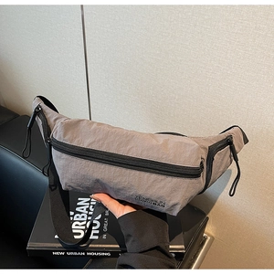 Détails d'un sac bandoulière en nylon gris avec texture plissée et sangle réglable
