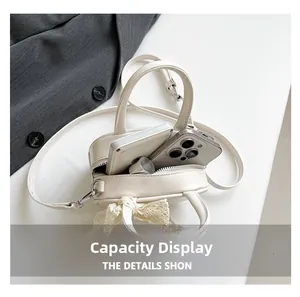 Capacity display of cream white mini crossbody bag with lace bow showing phone and lipstick