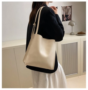 Detail view of cream vintage leather tote bag with soft texture and long shoulder straps