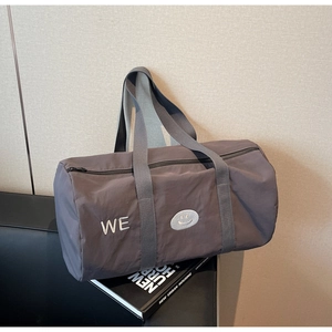 Dettaglio borsa da viaggio grigio-viola con ricamo WE e icona smile