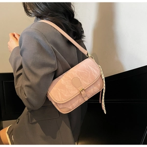Detail of pink marble pattern crossbody bag with scarf and gold buckle on a model