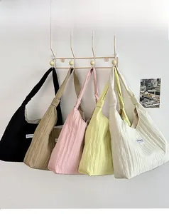 Detail of pleated tote bags in five colors showing vertical texture and wide shoulder straps