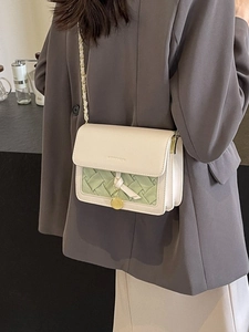Sac à bandoulière matelassé chic crème et vert, porté par un mannequin pour le style