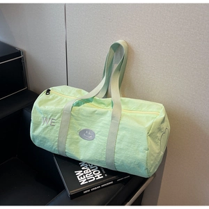 Dettaglio borsa da viaggio verde menta con ricamo WE e toppa con smiley