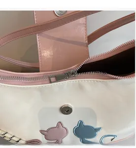 Detail view of smooth silver metal zipper and magnetic closure on pink shoulder bag