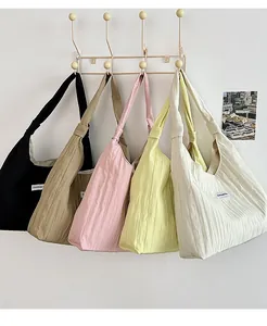 Detail view of five colors of minimalist large capacity canvas tote bags on hooks