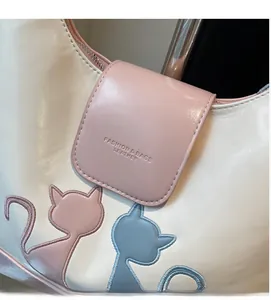 Detail view of cat embroidery and embossed fashion logo on soft leather tote bag