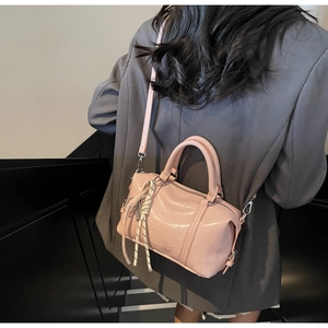 Detalle del bolso Boston rosa con textura de cuero brillante y grabado de letras en piel
