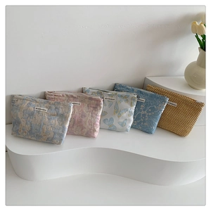 Collection of five woven fabric makeup pouches with floral patterns and zipper closure