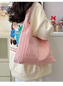 Pink pleated tote bag detail showing large capacity design and fabric brand label