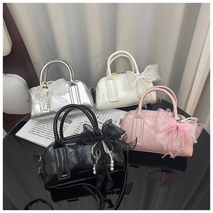 Gros plan de sacs Boston vintage en argent rose noir blanc avec détails de nœuds en dentelle
