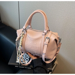 Detalle del bolso Boston rosa con texto en relieve y colgante de nudo trenzado