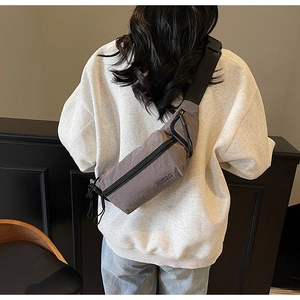 Vue arrière du mannequin portant un sac bandoulière taupe avec sangle réglable