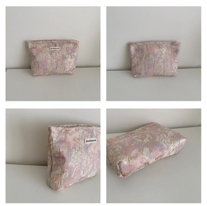Macro detail showing pink floral jacquard fabric texture and zipper closure of the bag