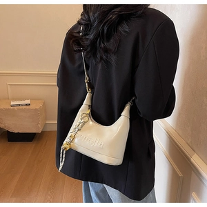 Detail view of cream dumpling shoulder bag with leather texture and sen&jia embossed logo