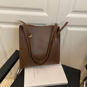Minimalist deep brown large capacity tote bag with smooth leather texture and gold buckles