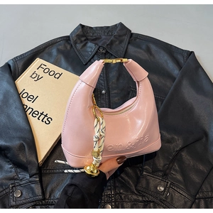 Detailed macro view of pink hobo handbag with embossed logo and metal hardware