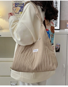 Detail of khaki pleated fabric tote bag with vertical texture and Duociyuan woven label