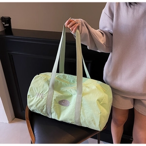 Dettaglio della borsa da viaggio verde menta con ricamo WE e patch con faccina