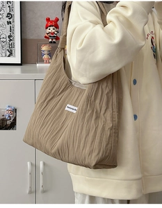 Detailed macro view of the pleated khaki fabric texture on this large shoulder tote bag