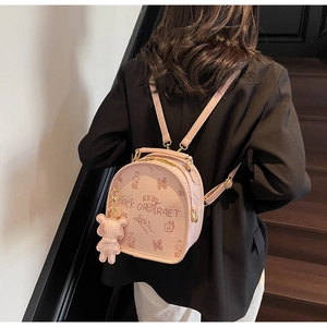 Pink mini backpack detail with bear charm and Trick or Treat print on leather