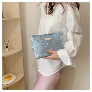 Detail of light blue floral jacquard makeup bag with white plum blossom pattern