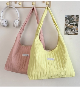 Detail of colorful nylon tote bags with knotted straps and square woven brand label
