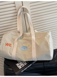 Borsa da viaggio in tela con ricamo WE e faccina su sedile in pelle nera