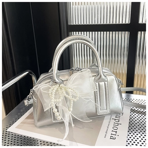 Détail de sac Boston argenté avec un nœud en organza blanc et des perles de luxe