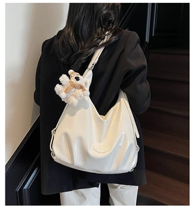 Grand sac fourre-tout blanc brillant plissé avec peluche ours porté à l'épaule par un mannequin