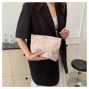 Close-up of pink and purple woven fabric texture on compact makeup bag with zipper