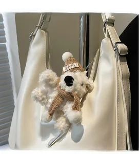 Détail d'un pendentif chien en peluche avec bonnet Lovely sur un sac à main blanc