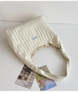 Detailed view of off-white pleated tote bag with Duociyuan brand label and vertical pleats