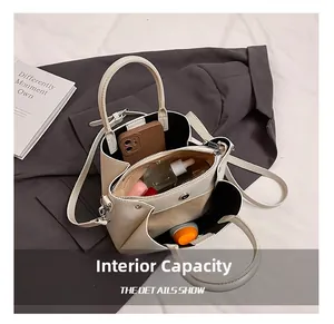 Internal capacity of the cream bucket bag showing inner pockets and makeup essentials