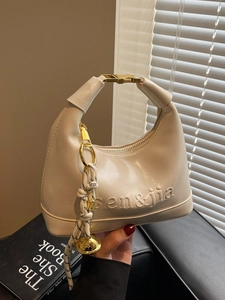 Creamy crescent hobo handbag with gold clasp and decorative braided rope charm