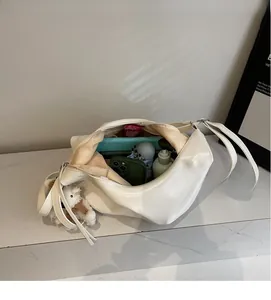 Intérieur spacieux d'un sac cabas crème montrant le rangement d'objets du quotidien