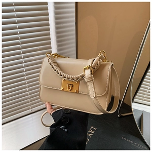 Détail du sac à bandoulière vintage beige avec poignée tressée et fermoir doré