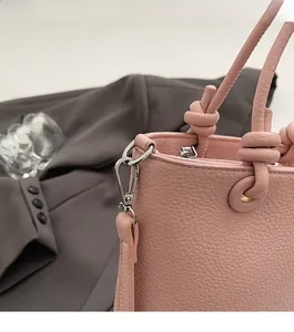 Dettaglio borsa a secchiello in pelle rosa grana litchi con gancio in metallo argento