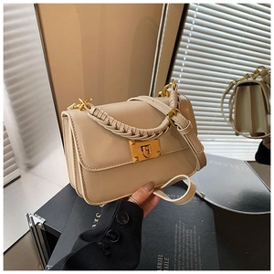 Détail du sac en cuir abricot avec une poignée tressée épaisse et un fermoir doré