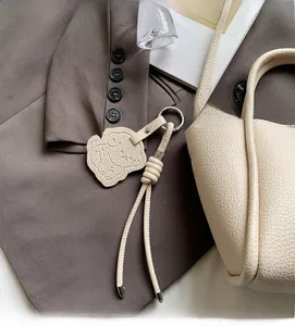Détail d'un pendentif en cuir crème avec motif de chien sur un sac à main