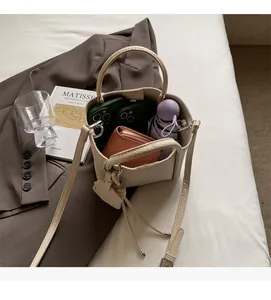 Vue de dessus d'un sac seau blanc crème montrant un grand espace pour les accessoires