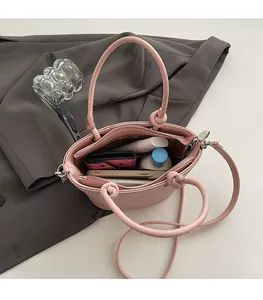 Vista dall'alto della borsa a secchiello rosa con interno spazioso, zip e fodera marrone