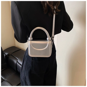 Detail of silver metallic mini square bag with glossy mirror finish and top handle