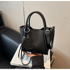 Détail du mini sac cabas en cuir grainé noir avec poignée et breloque petit chien